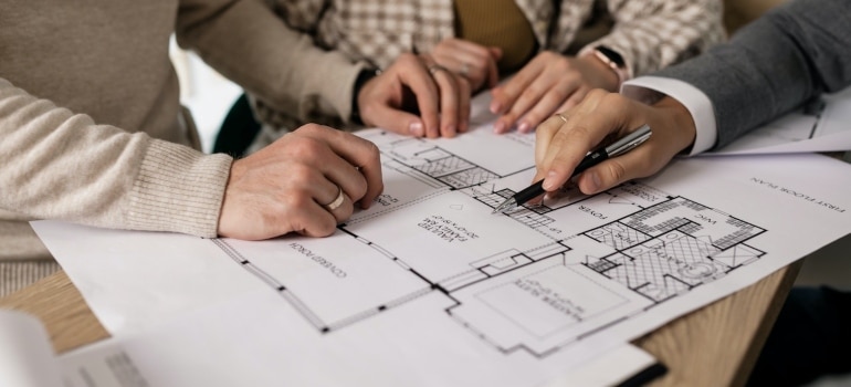 a family looking at a floor plan before investing in Broward County real estate