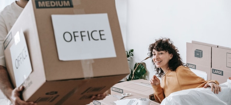 A man carrying a box labeled office.