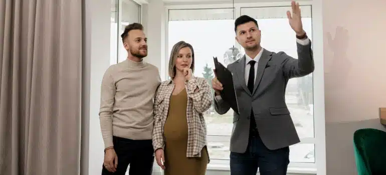a couple with a real estate agent discussing about benefits of renting storage before having a baby