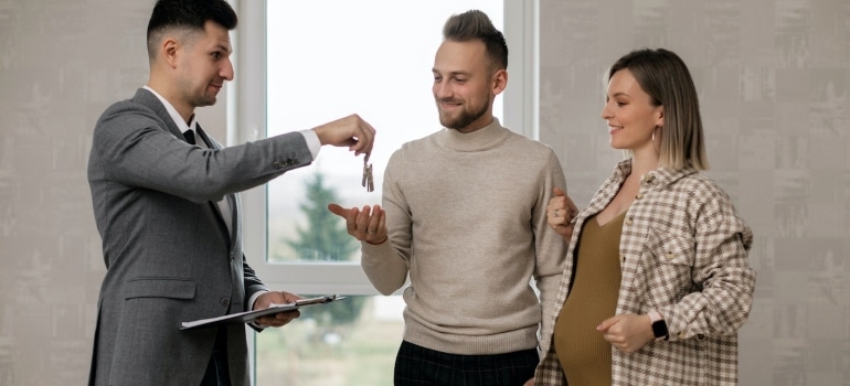 a couple with a real estate agent about to invest in Coral Spring's real estate