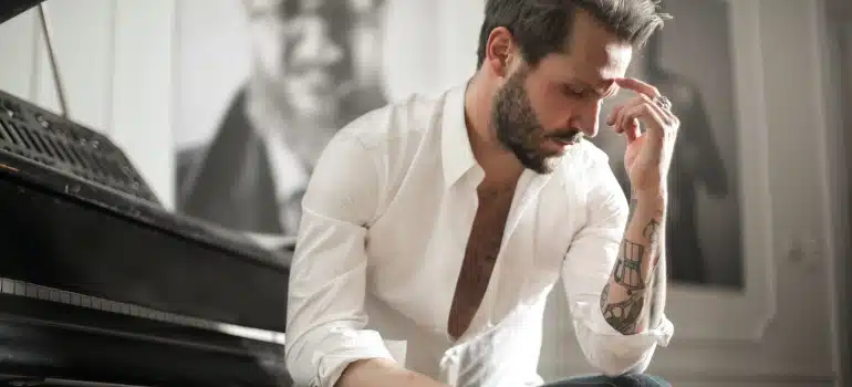 a man next to a piano thinking about prepare for moving your piano to Kendall