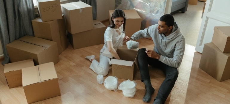a couple unpacking a box with fragile items