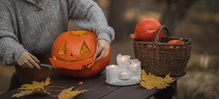 a woman carving a pumpkin before visiting Pumpkin festival, one of the best things to do in Coconut Grove