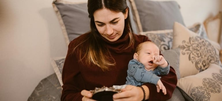 a woman with a baby looking at a photo in a frame