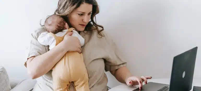 a mom with a baby in her arms browsing the net searching for The fastest way to move house with a baby 