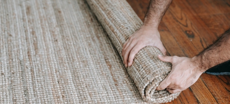 a person preparing for storing carpets when moving from NY to Florida