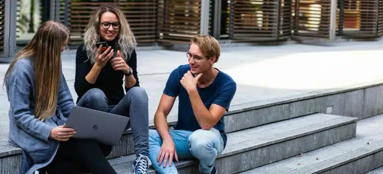 Millenials sitting on stairs and talking about Top reasons why Edgewater is suitable for millennials