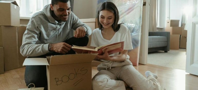 a couple packing and talking about the move a home library to Homestead