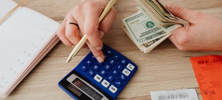 a person using a calculator holding money