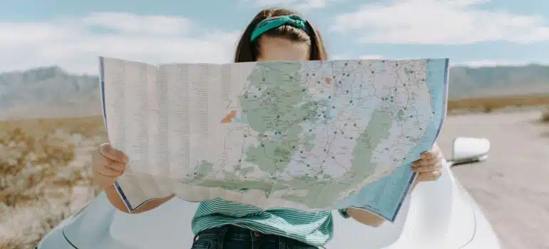 a woman with a map searching for the most exclusive neighborhoods in Miami to move to