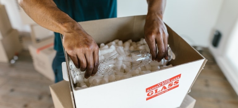 a person packing glassware