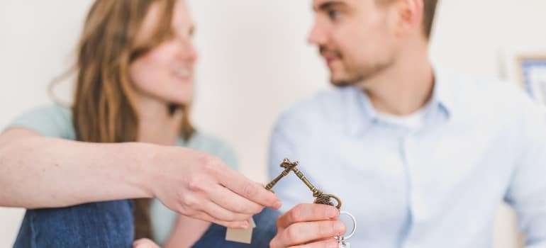 a couple holding keys and talking about finding affordable apartments for singles in Coral Gables 