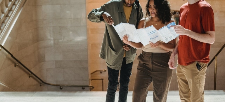 young adults searching for the most exclusive neighborhoods in Miami to move using a map