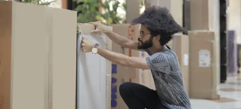 a man packing boxes and moving an IT office to Miami