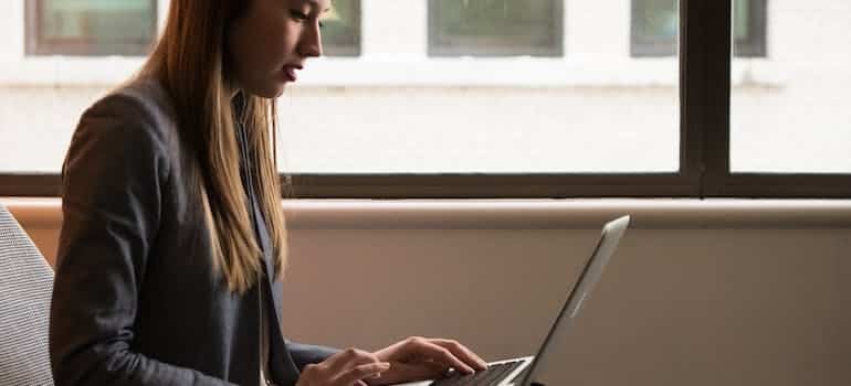 a woman reading on a laptop about how to handle moving delays when relocating from Brickell to Edgewater