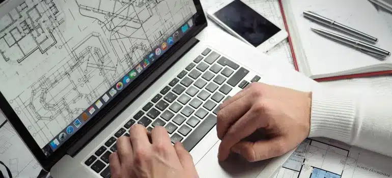 a man looking at a floor plan on a laptop