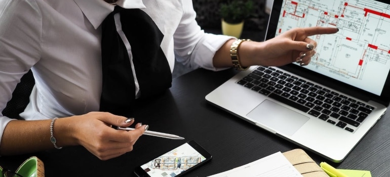 a person piint at a laptop screen at a floor plan