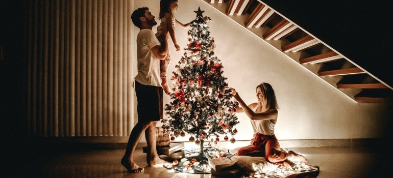 A family decorating their Christmas tree before enjoying Miami holiday events for kids
