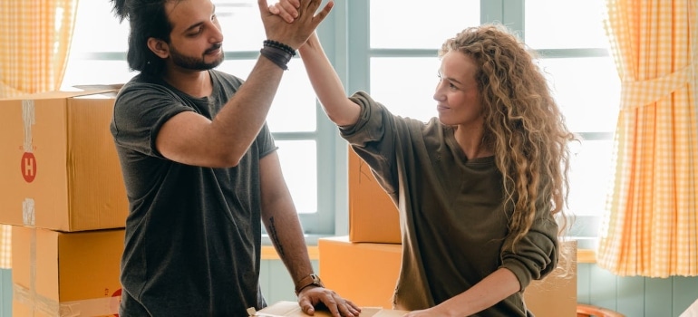 a happy couple high five after moving during Christmas holidays