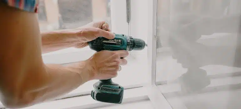 workman screwing a window frame