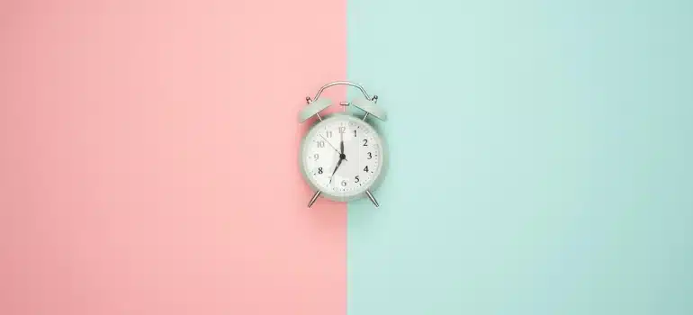 a clock on a pink and blue background