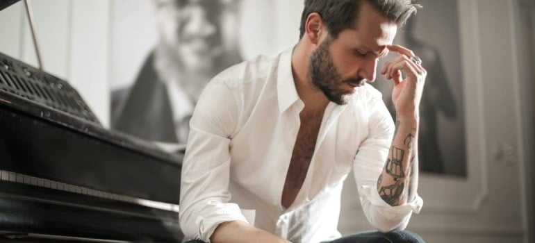 a man next to a piano thinking about moving services to use when moving your piano