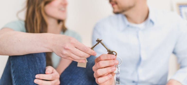 a couple holding a key of the house before moving from South Miami to North Miami