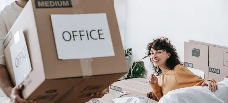 a man carrying a box labeled office before relocating to one of the Best places in Broward County for your business