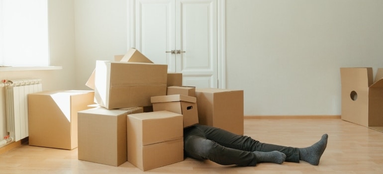 a man under the boxes thinking about How to declutter your Pompano Beach home before the move