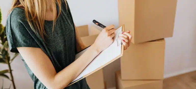 a woman making a list of what to pack and unpack for the move from Miami to Fort Lauderdale