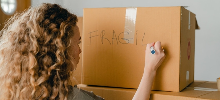 a woman labeling a box