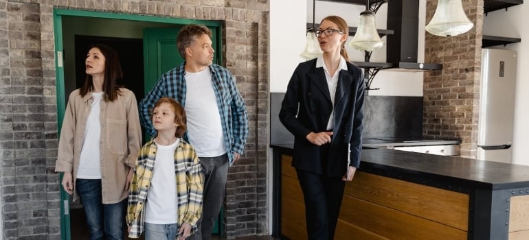 a family inspecting a home with a real estate agent