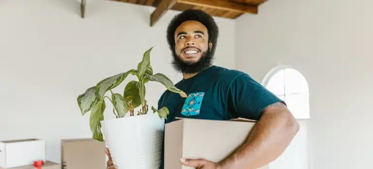 a mover carrying a box and a plant