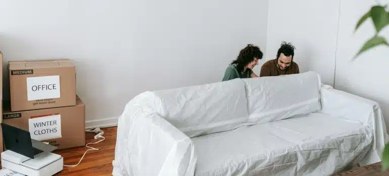 a couple lifting a sofa