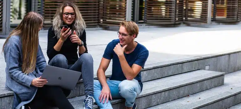 students sitting on stairs talking about Best colleges in Miami