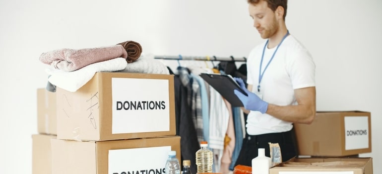 a man surrounded by boxes for donations before spring cleaning your Fort Lauderdale home