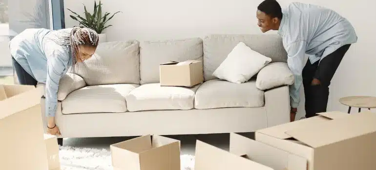a couple lifting a sofa