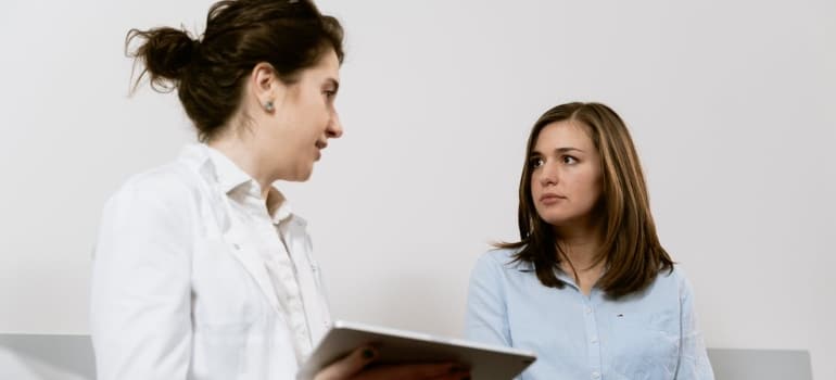 a gynecologist talking to a pregnant woman about moving a medical center in Florida