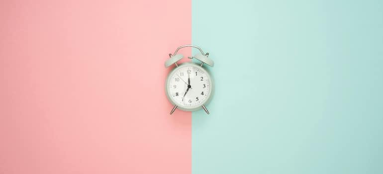 a clock on a pink and blue background