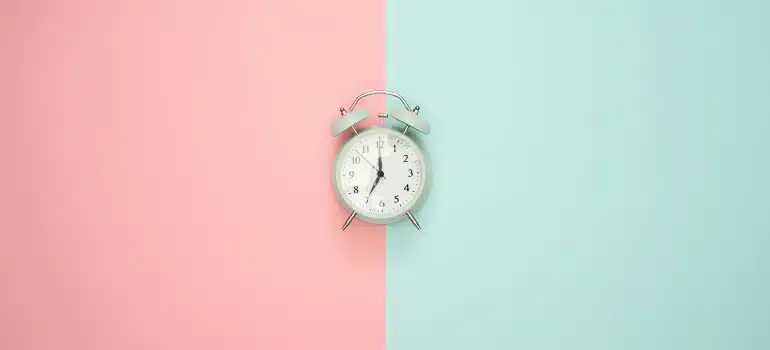 a clock on a pink and blue background