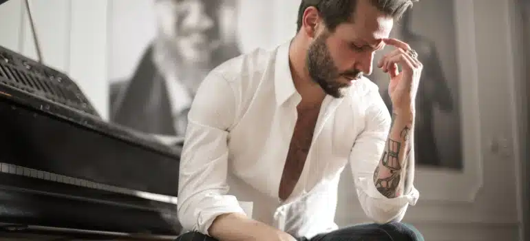 a man next to a piano thinking how to move musical instruments long distances