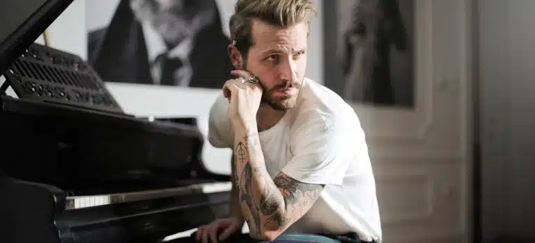 a man next to a piano thinking how to move musical instruments long distances