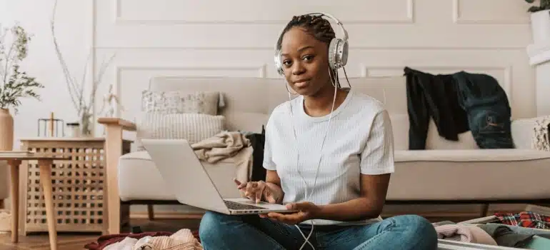 a woman using a laptop when packing, probably reading Florida weather guide for newcomers.