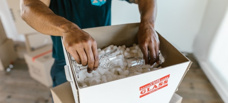 A mover packing crystal glasses covered by moving insurance