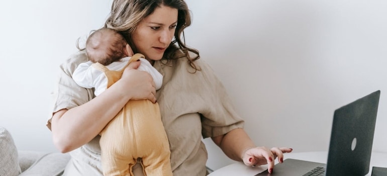 a woman holding a baby searching the net for ways to make your new Fort Lauderdale home baby-friendly