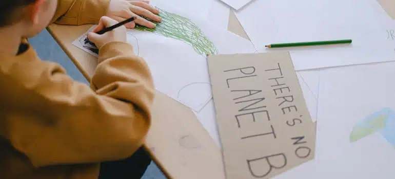 a child writing "there's no planet B" on the box, as one of the best ways to reuse packing materials