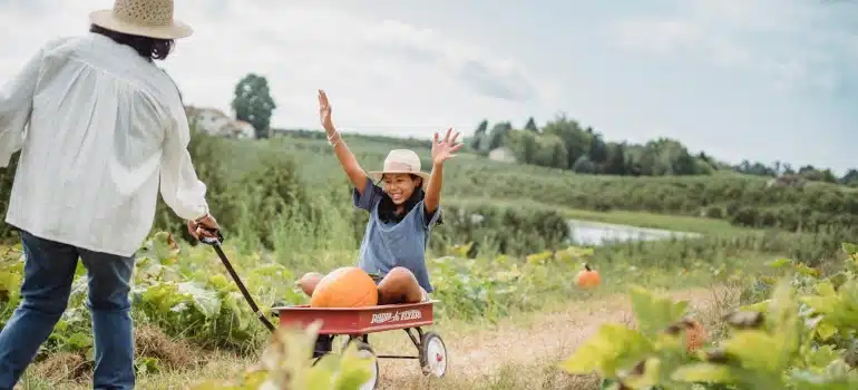 a woman in a cart on a farm getting pumpkin patches in Miami for seasonal décor and fall fun