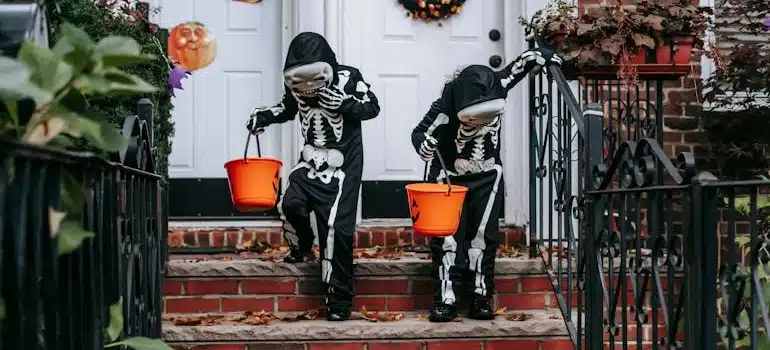 Two kids in Halloween costumes trick or treating together