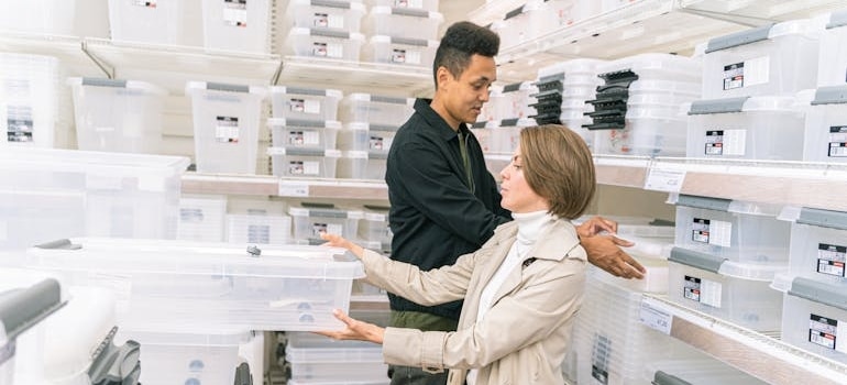A couple in a shop choosing plastic boxes to store Halloween decorations