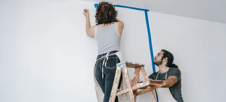 a couple renovating walls before they sell your luxury property in Miami before leaving Florida